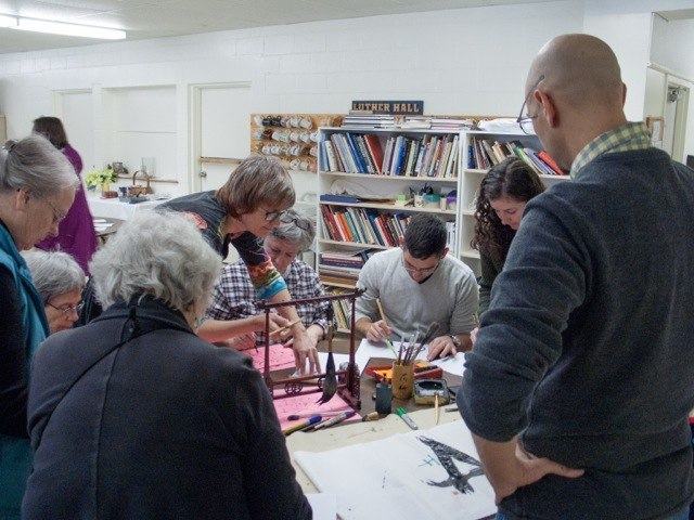Jim Davies watches on as CSO members write with paintbrushes at Popup Studio 2016